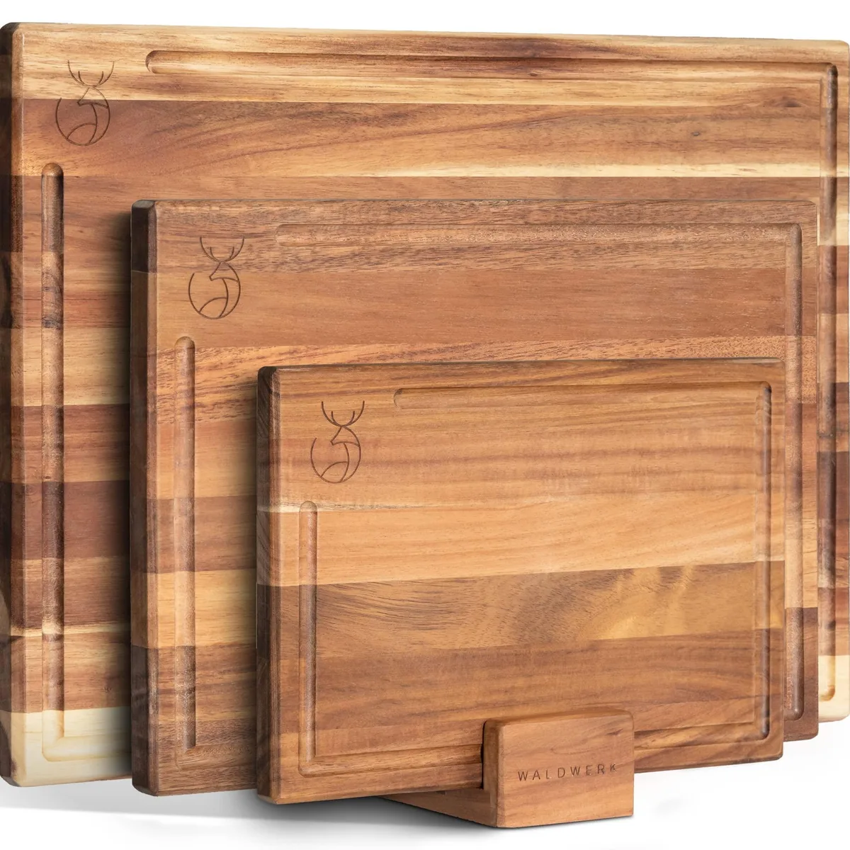 Three rectangular acacia cutting boards in a wooden stand, showing natural wood grain and juice grooves