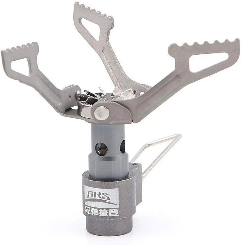 Tiny titanium stove with folded pot supports beside bright green pouch