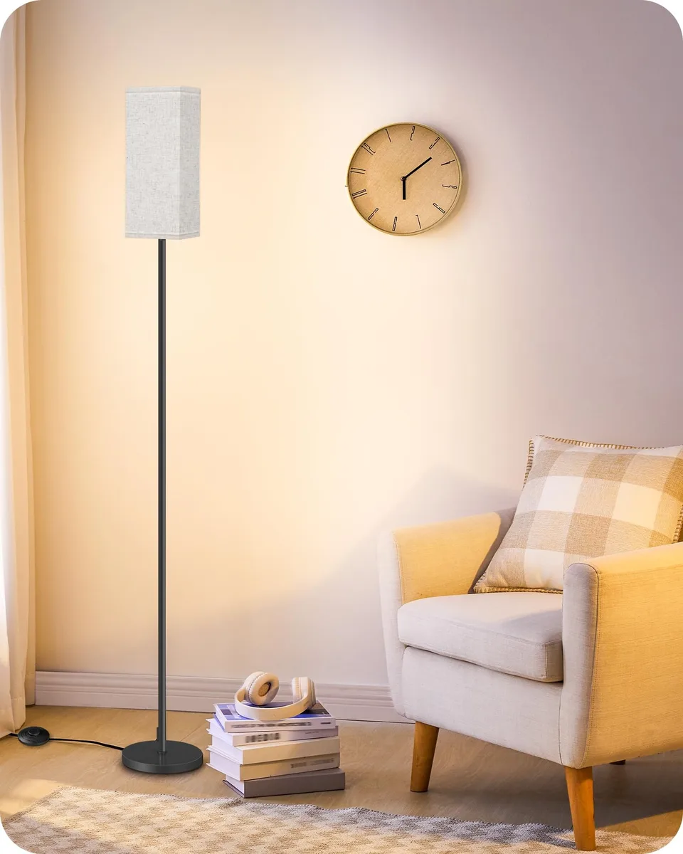 Tall black metal floor lamp with beige linen shade, foot switch on pole