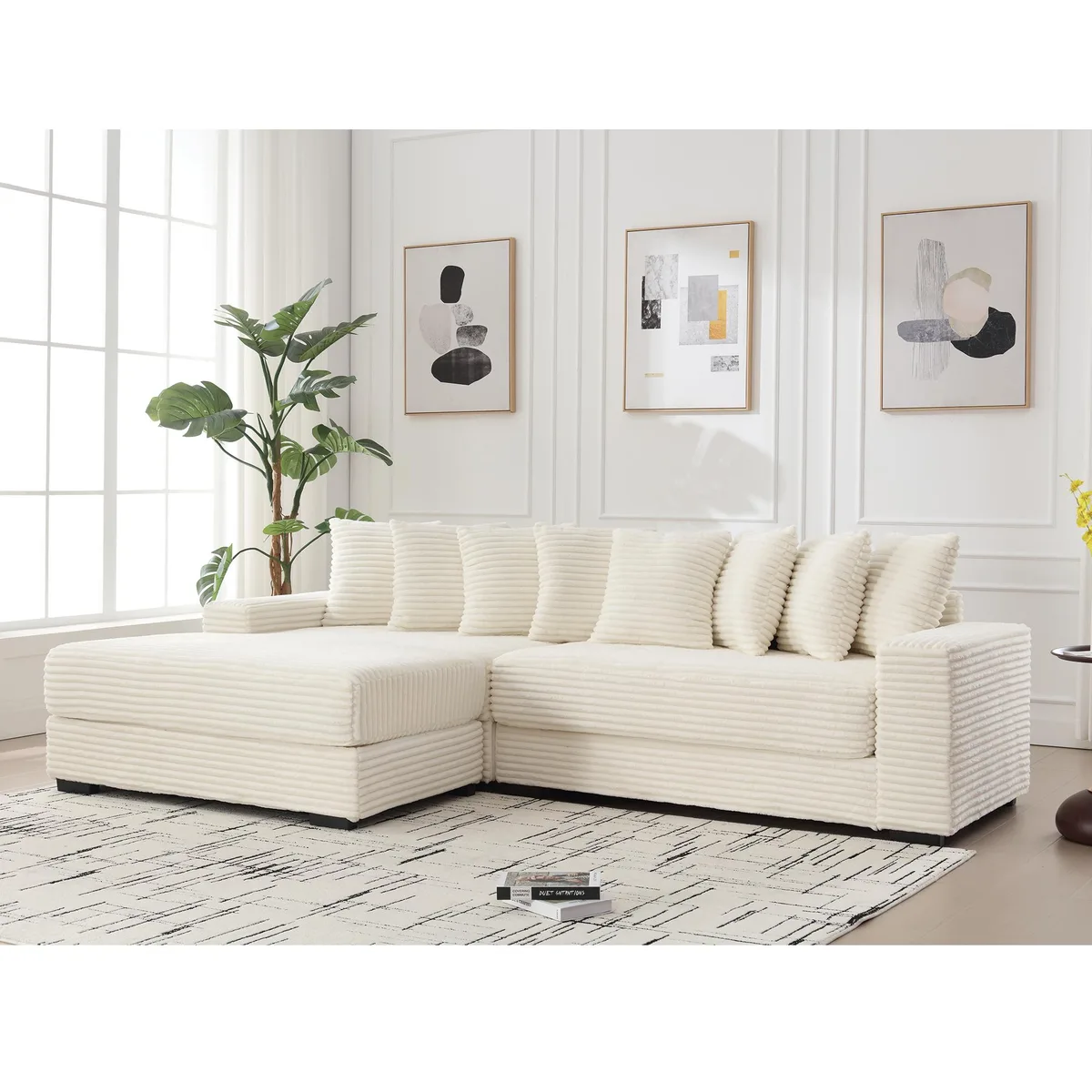 Beige corduroy L-shaped sofa with left chaise, armrests, eight pillows, black plastic legs
