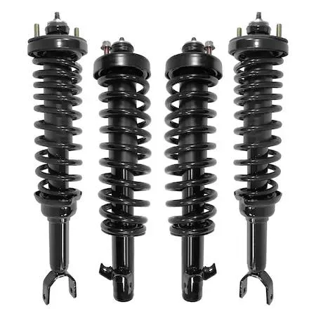 Four silver strut assemblies with coiled springs and top mounts on a grey surface