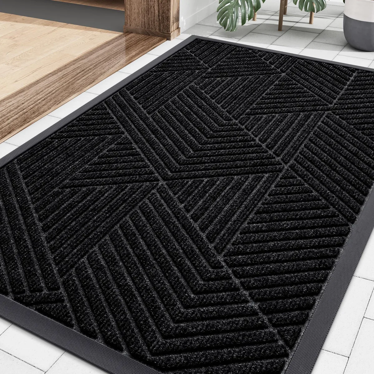 Black rectangular doormat with irregular triangle pattern, low profile rubber backing