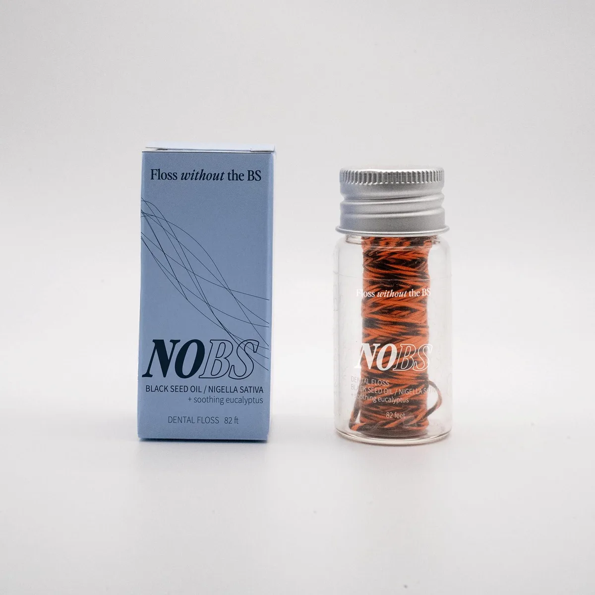 Small glass jar holding 82 foot expanding eucalyptus dental floss