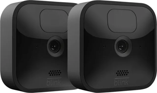 Two white square wireless cameras with mounts and a small sync module box