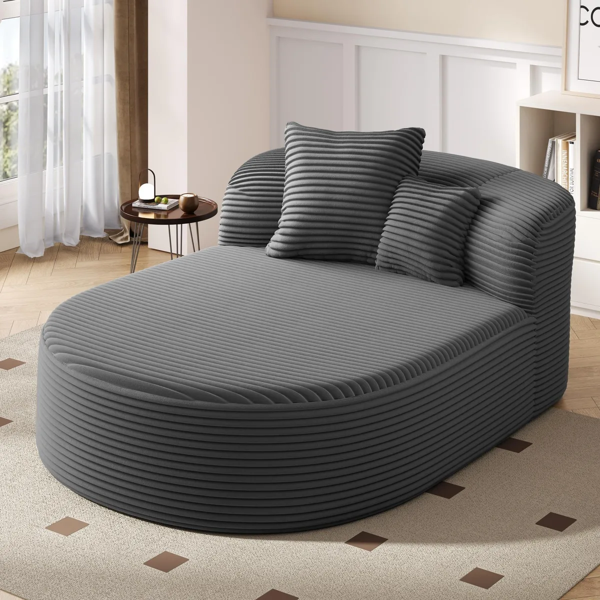 Gray corduroy chaise lounge with curved arc silhouette and two throw pillows