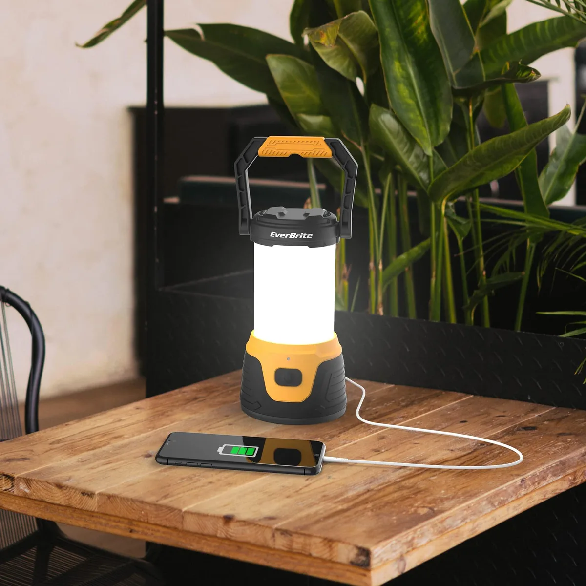 Black cylindrical LED camping lantern with carry handle and USB ports