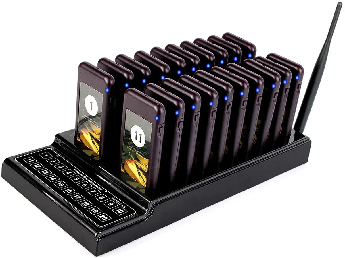 White rectangular charging base with twenty small pagers slotted in rows