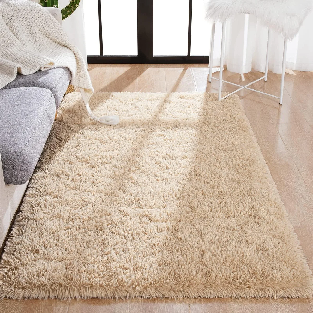 Rectangular light tan rug with fluffy polyester surface and non-slip backing