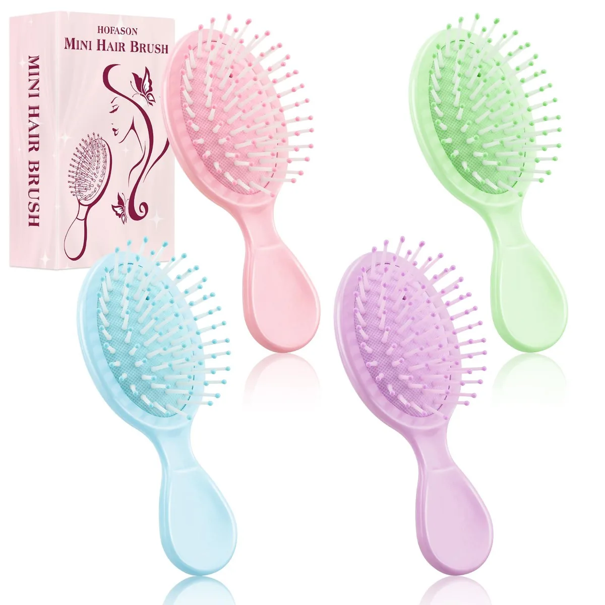 Four small rectangular hair brushes in pastel macaron colours lying side by side