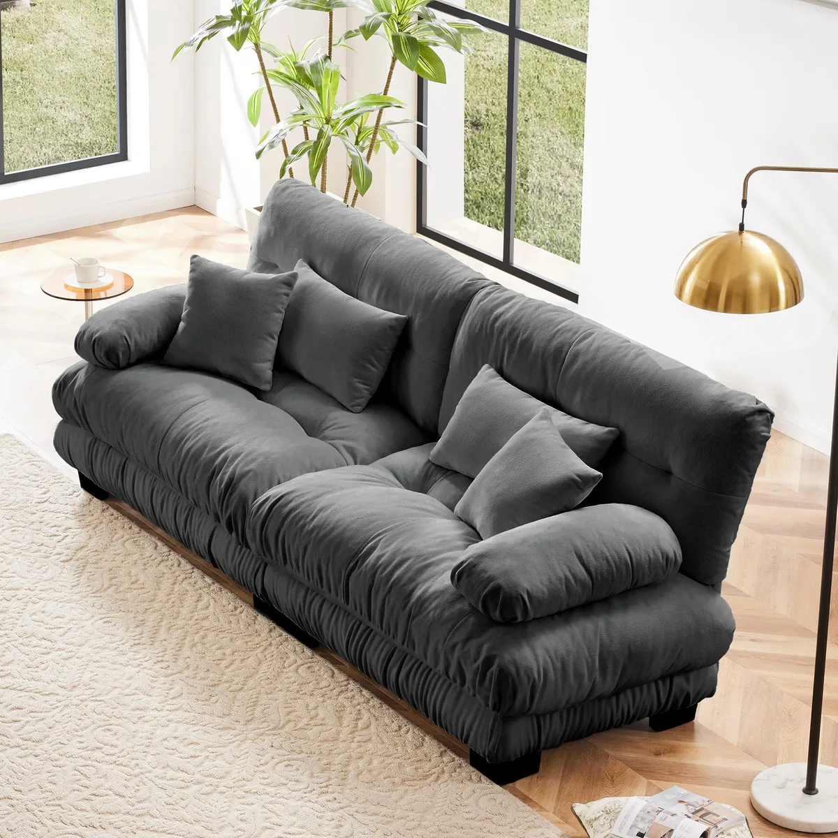 Gray chenille two-seater sofa with rounded bolster armrests, two lumbar and two throw pillows