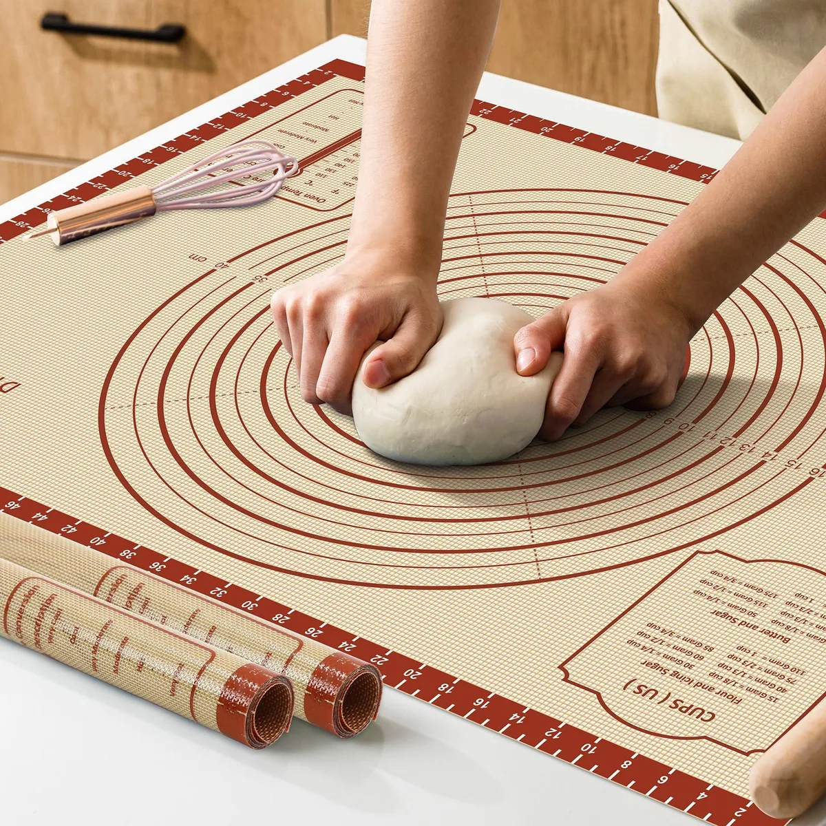 Large rectangular silicone baking mat with red checkered measurement grid and bold white markings on light surface