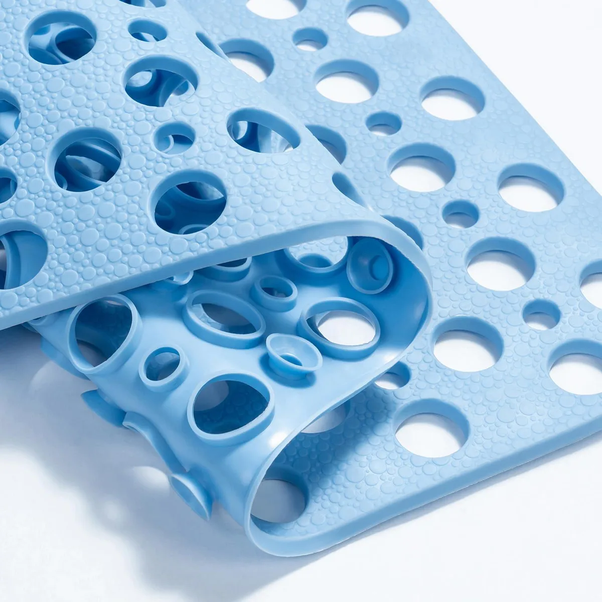 Rectangular blue TPE bath mat with suction cups and drainage holes, 28 by 15 inches