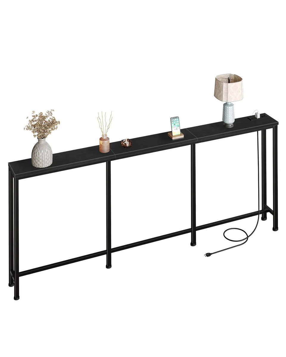Long black console table with metal frame and power strip visible