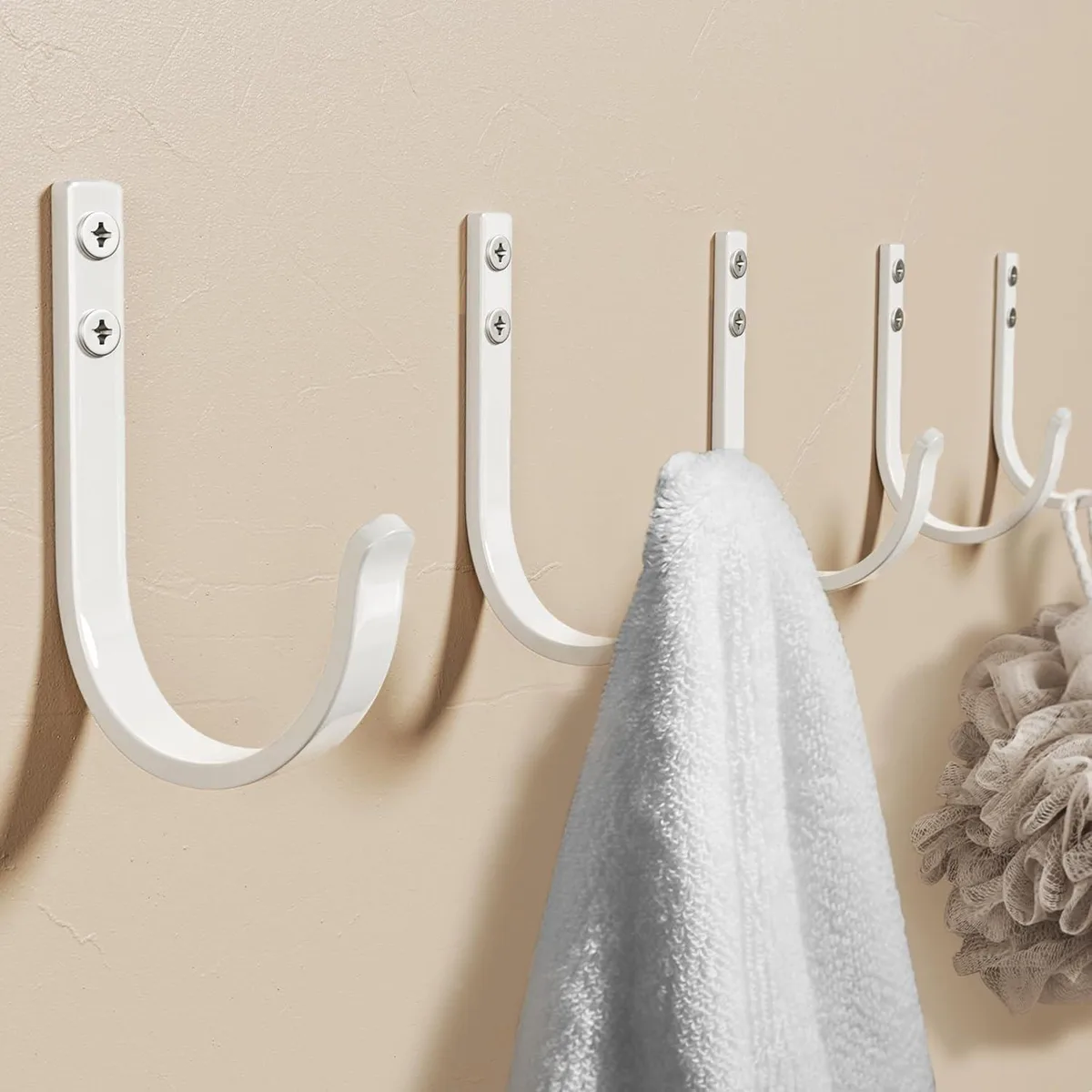 Five white matte aluminium wall hooks in a row