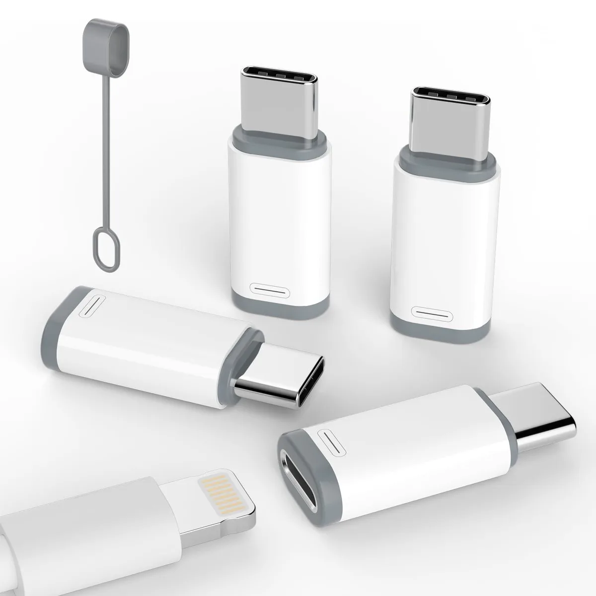 Four small silver Lightning to USB C adapters on a plain surface