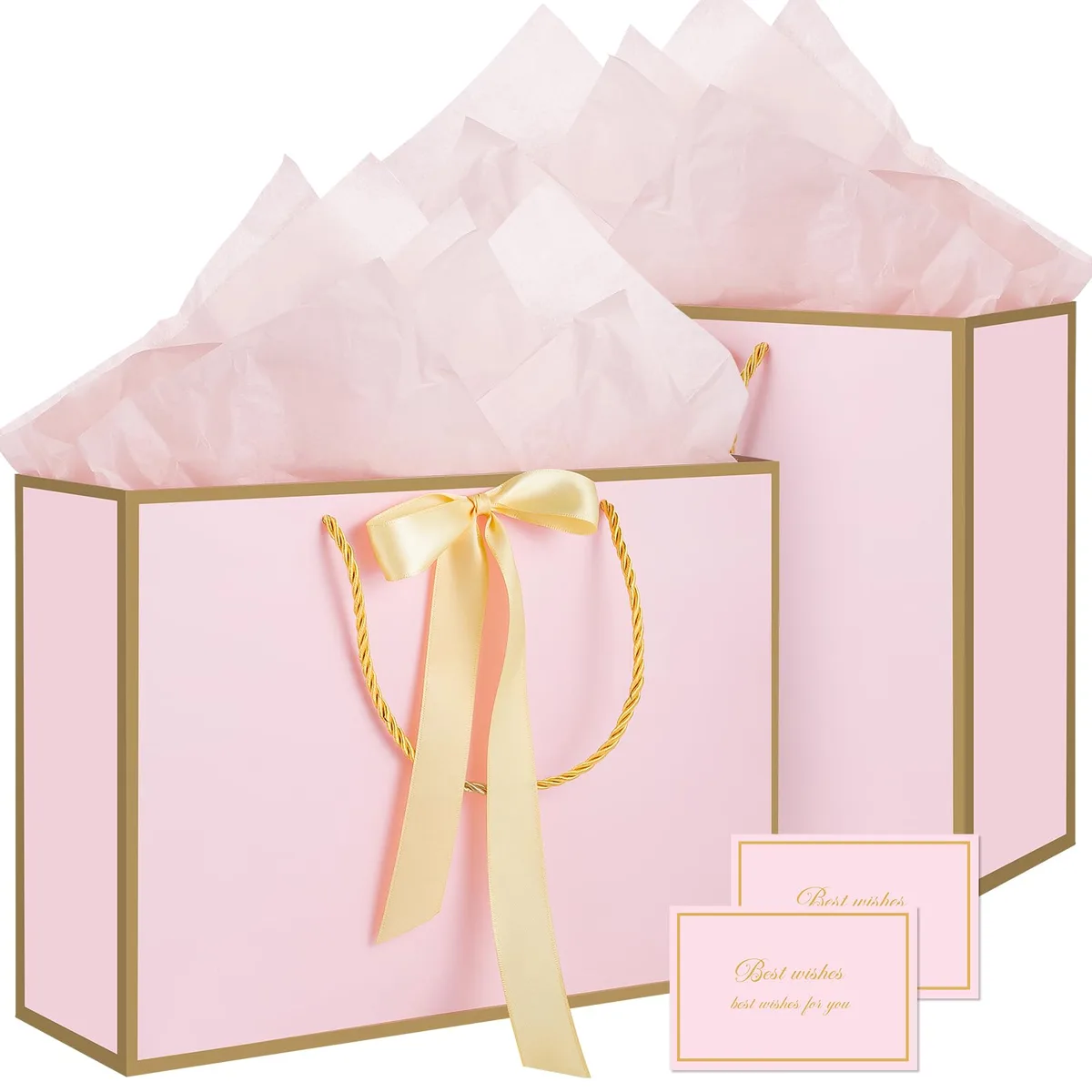 Two pink medium gift bags with gold rope handles and gold-trimmed edges, plus tissue paper and cards