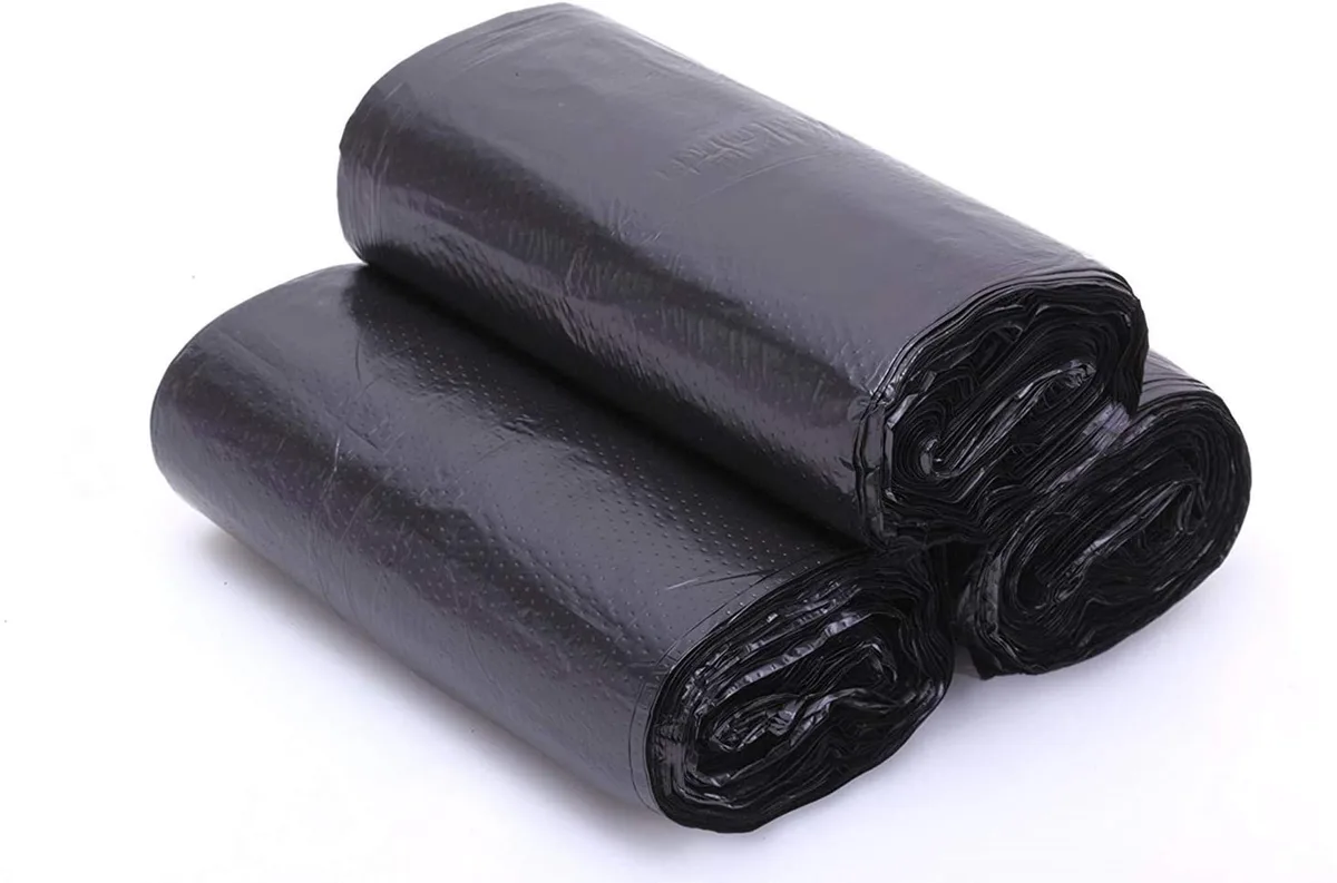 Four rolls of black plastic trash bags in white box, 120 count total