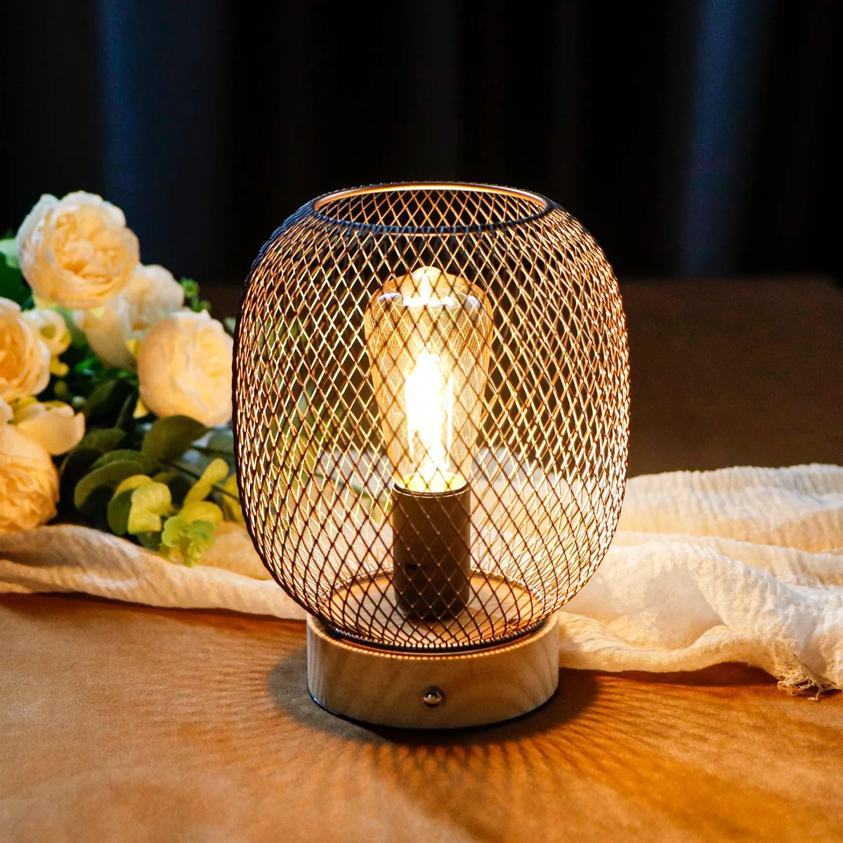 Metal cage table lamp with wooden base and warm LED bulb