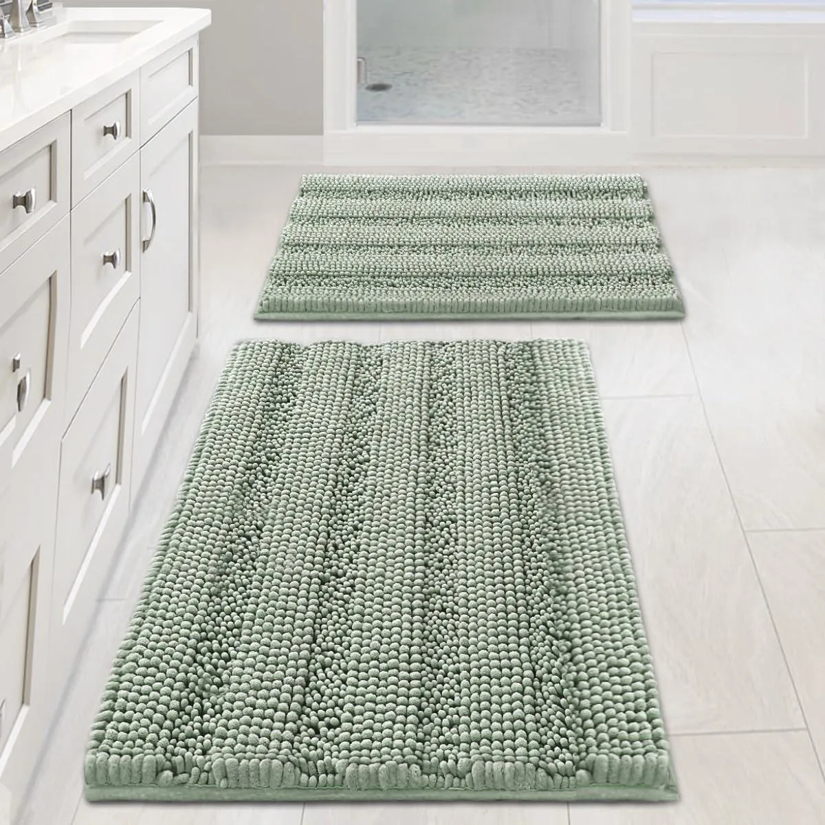 Two rectangular sage chenille bath rugs, one 20 by 32 inches and one 17 by 24 inches, thick shaggy pile with striped pattern
