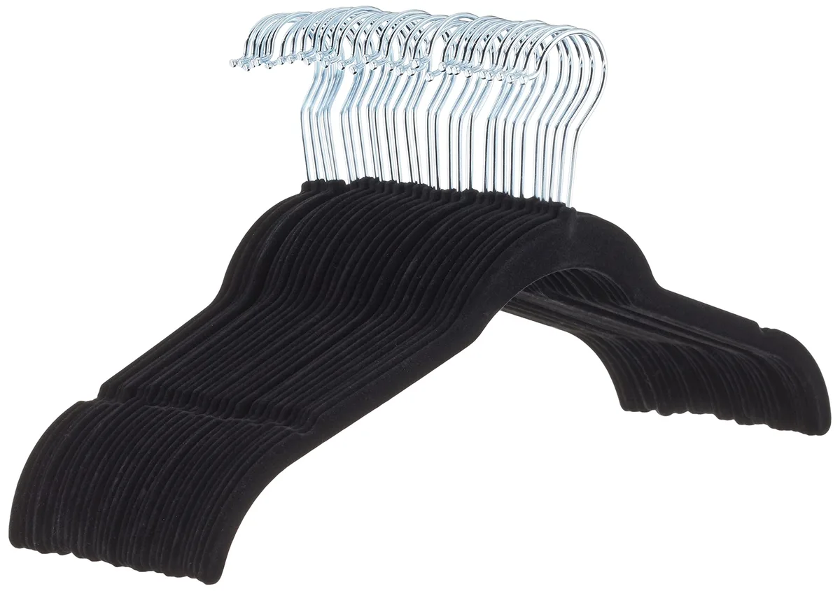 Thirty slim black velvet hangers with silver hooks and shoulder notches, stacked together