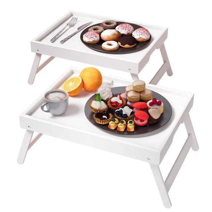 Two white bamboo bed trays with folded legs and guardrails