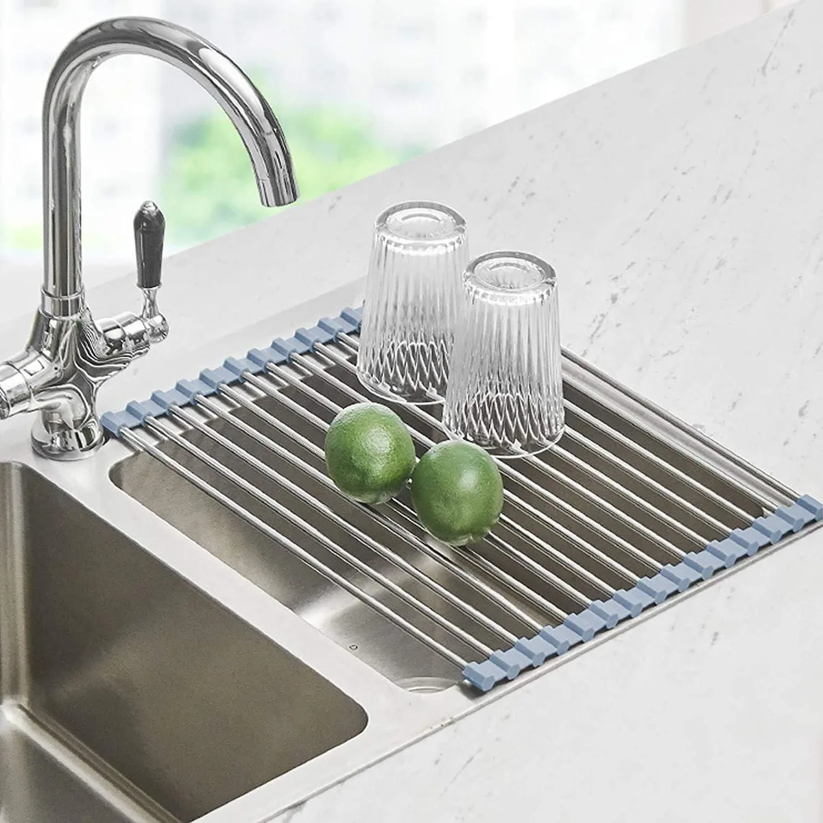 Red roll-up drying rack with stainless steel tubes over a kitchen sink