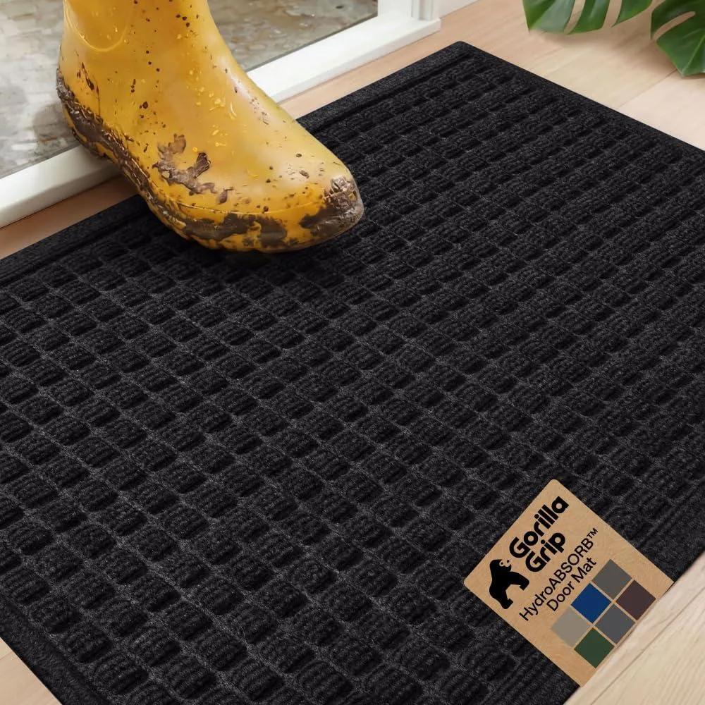 Black rectangular door mat with raised square pattern and rubber backing