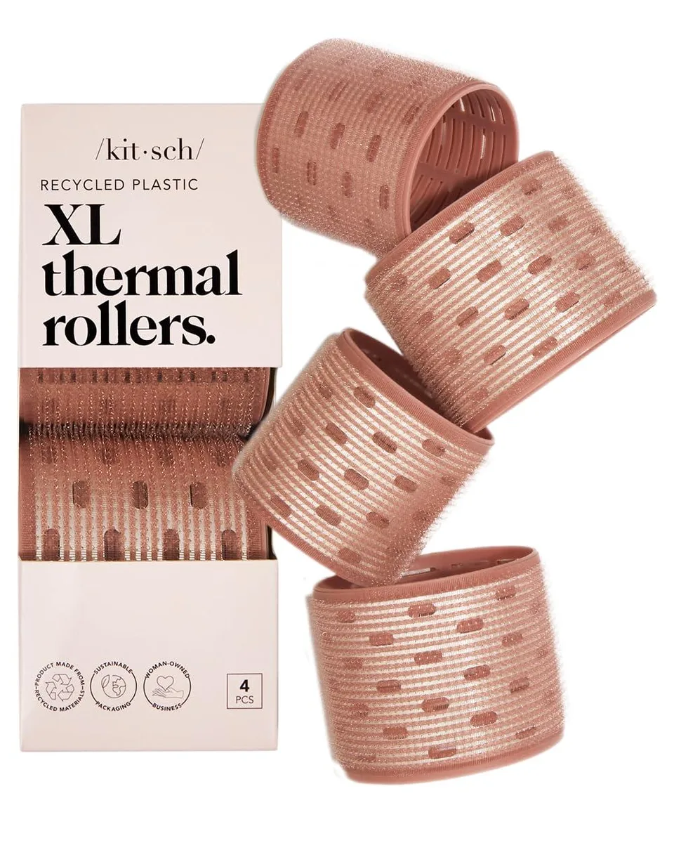 Four terracotta ceramic hair rollers on a light surface