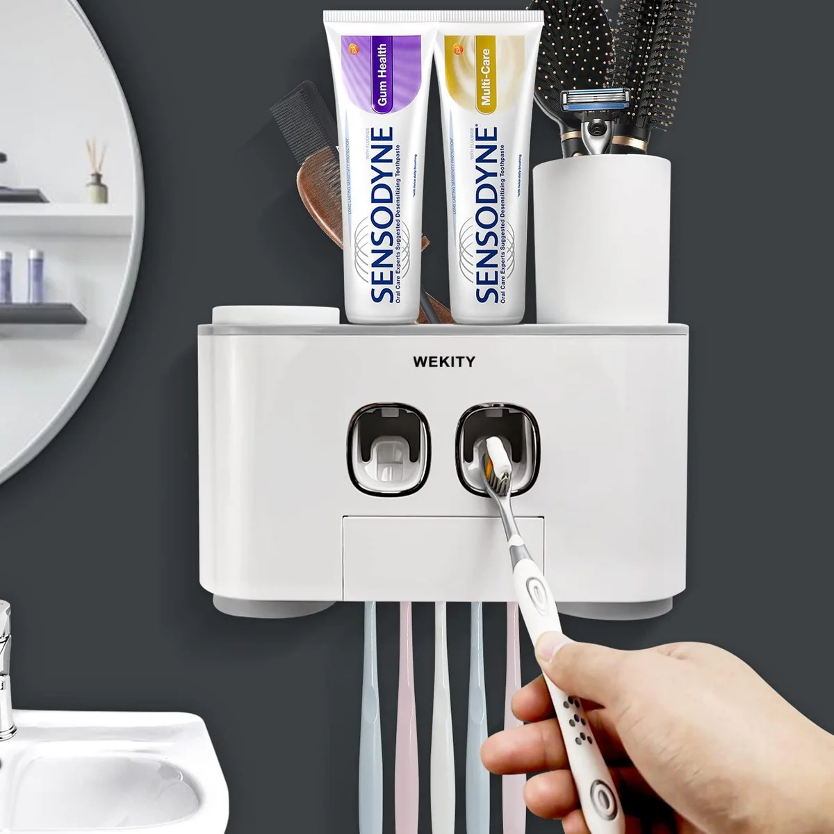 Grey wall-mounted toothbrush holder with four upside-down cups, two toothpaste dispensers and five brush slots