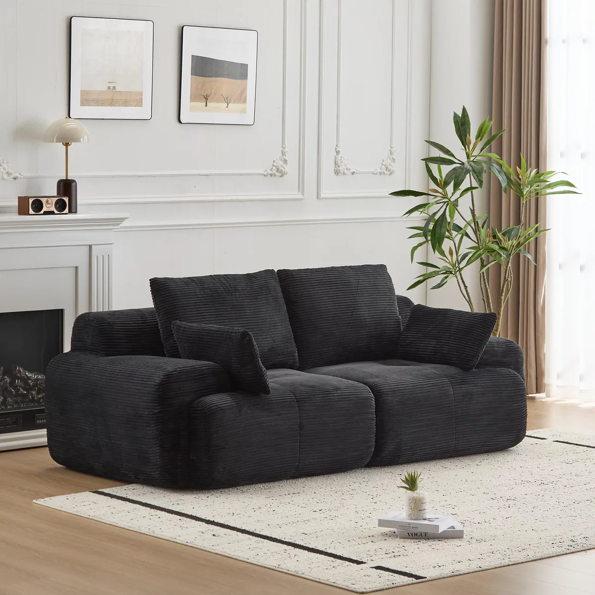 Black corduroy two-seater sectional sofa, deep seat with bolsters and throw pillows