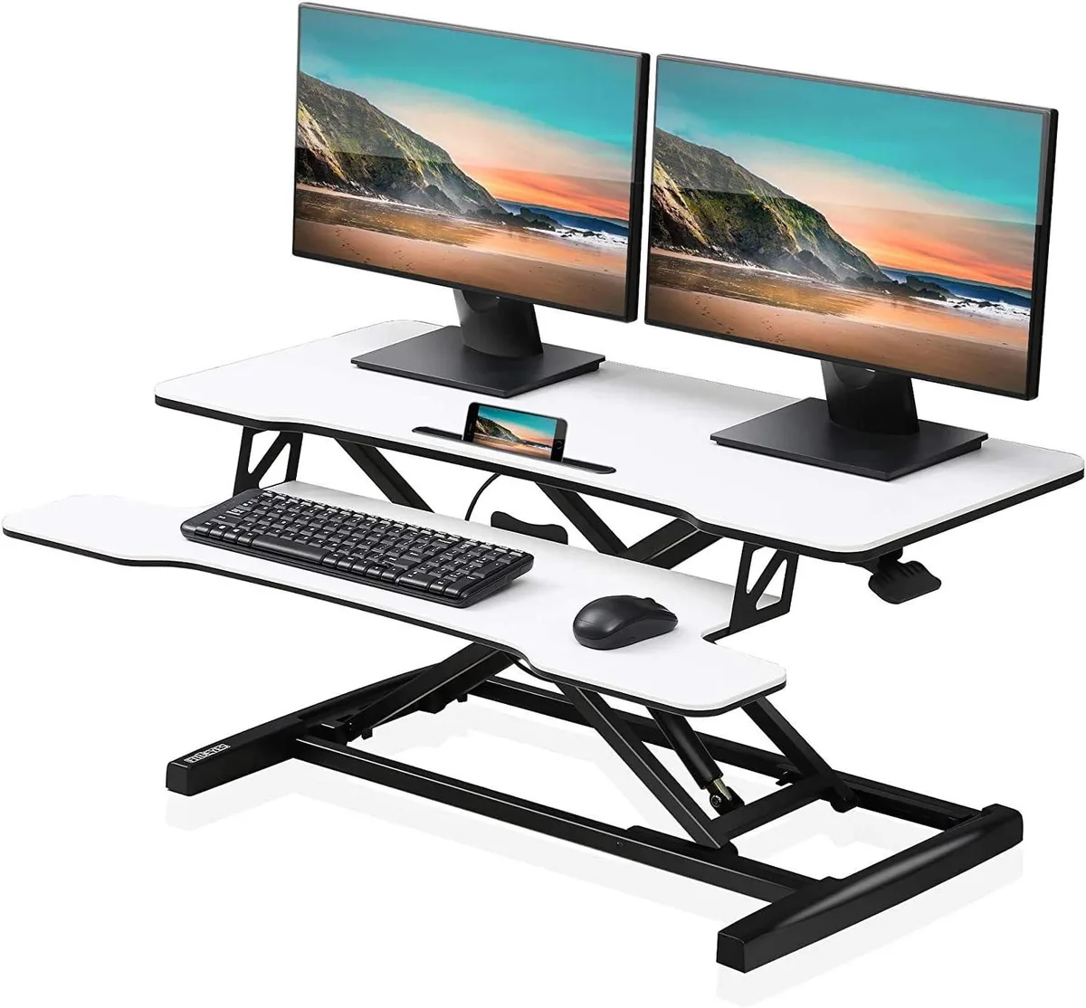 White rectangular standing desk converter with gas-spring lift mechanism and two-tier surface, raised to standing height