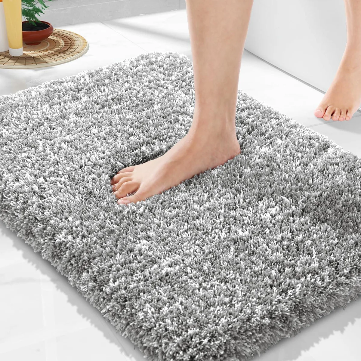 Light gray and white microfiber bath mat, fluffy rectangular shape, non-slip backing
