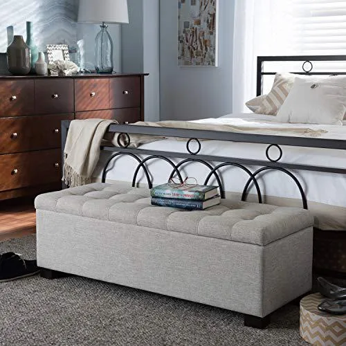 Beige upholstered storage ottoman bench with grid-tufted hinged lid and black wooden legs