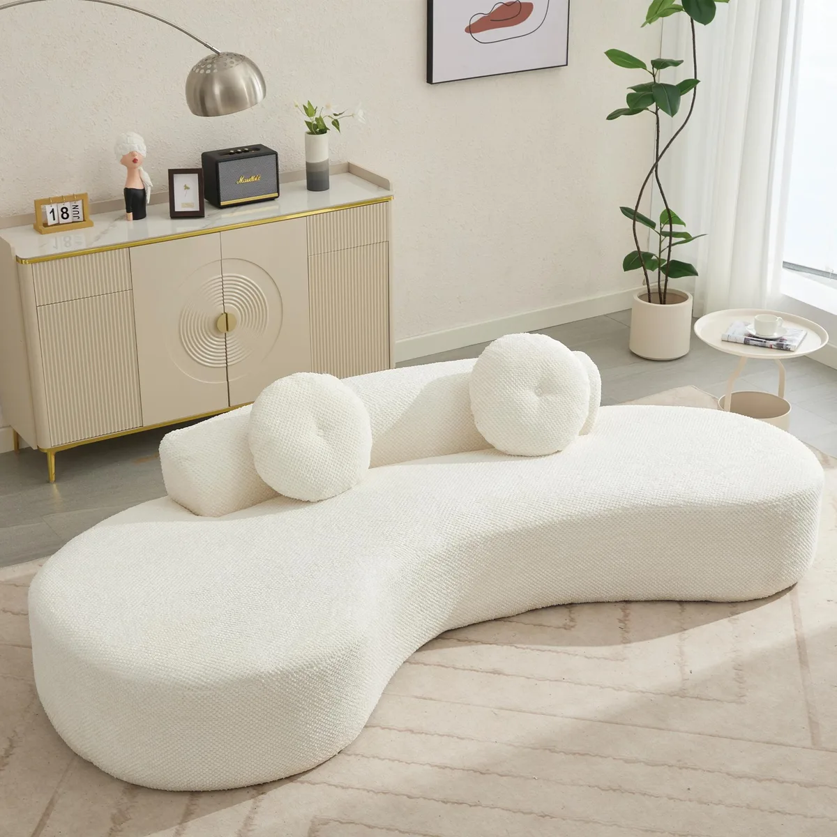 Large curved beige corduroy sofa with two matching pillows, low profile, wide deep seat
