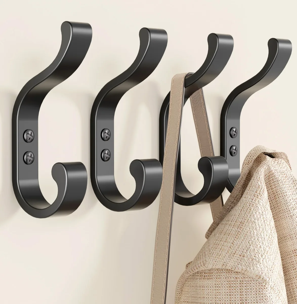 Four black metal wall hooks with dual curved arms and mounting hardware