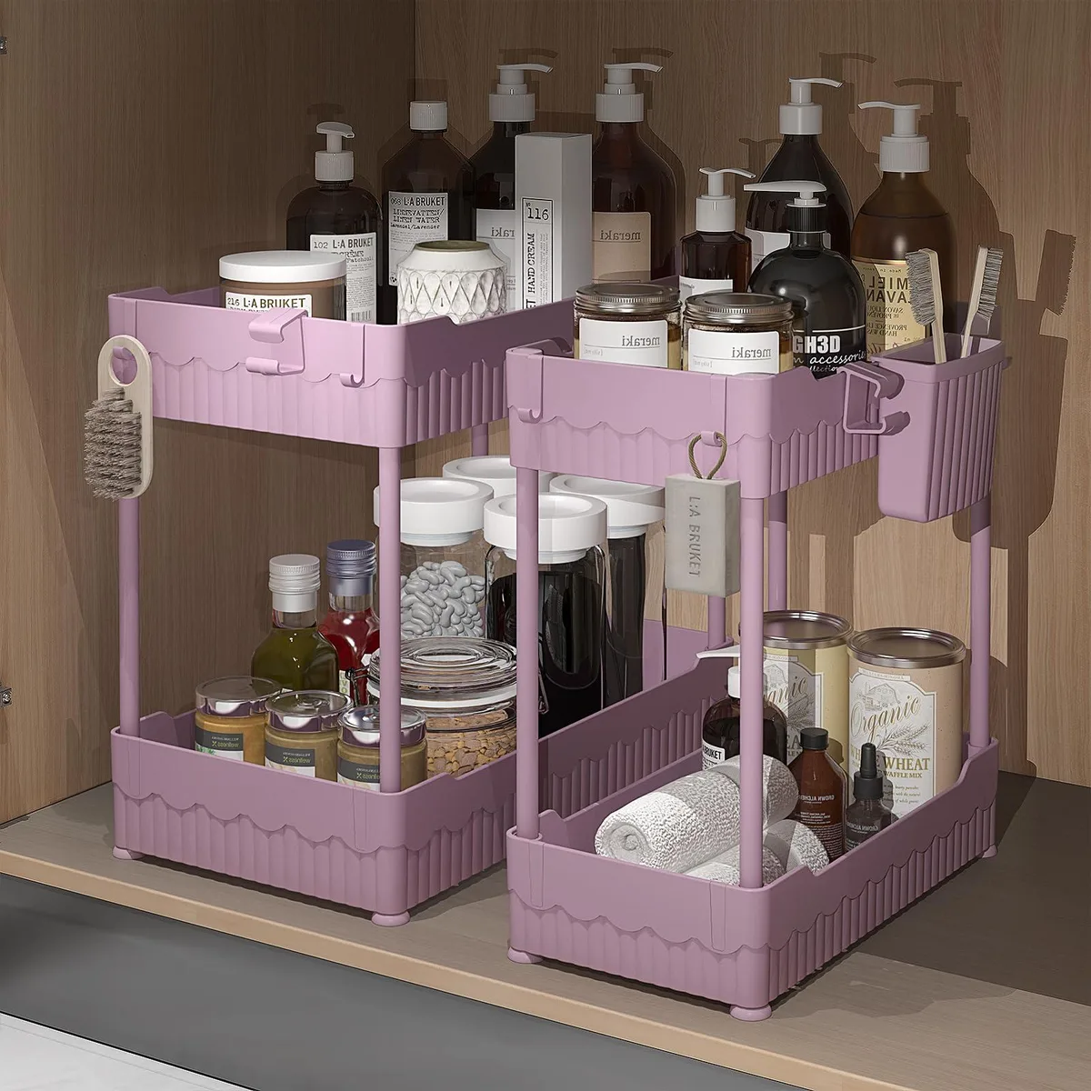 Two pink tiered plastic shelves with hooks and a hanging cup side by side