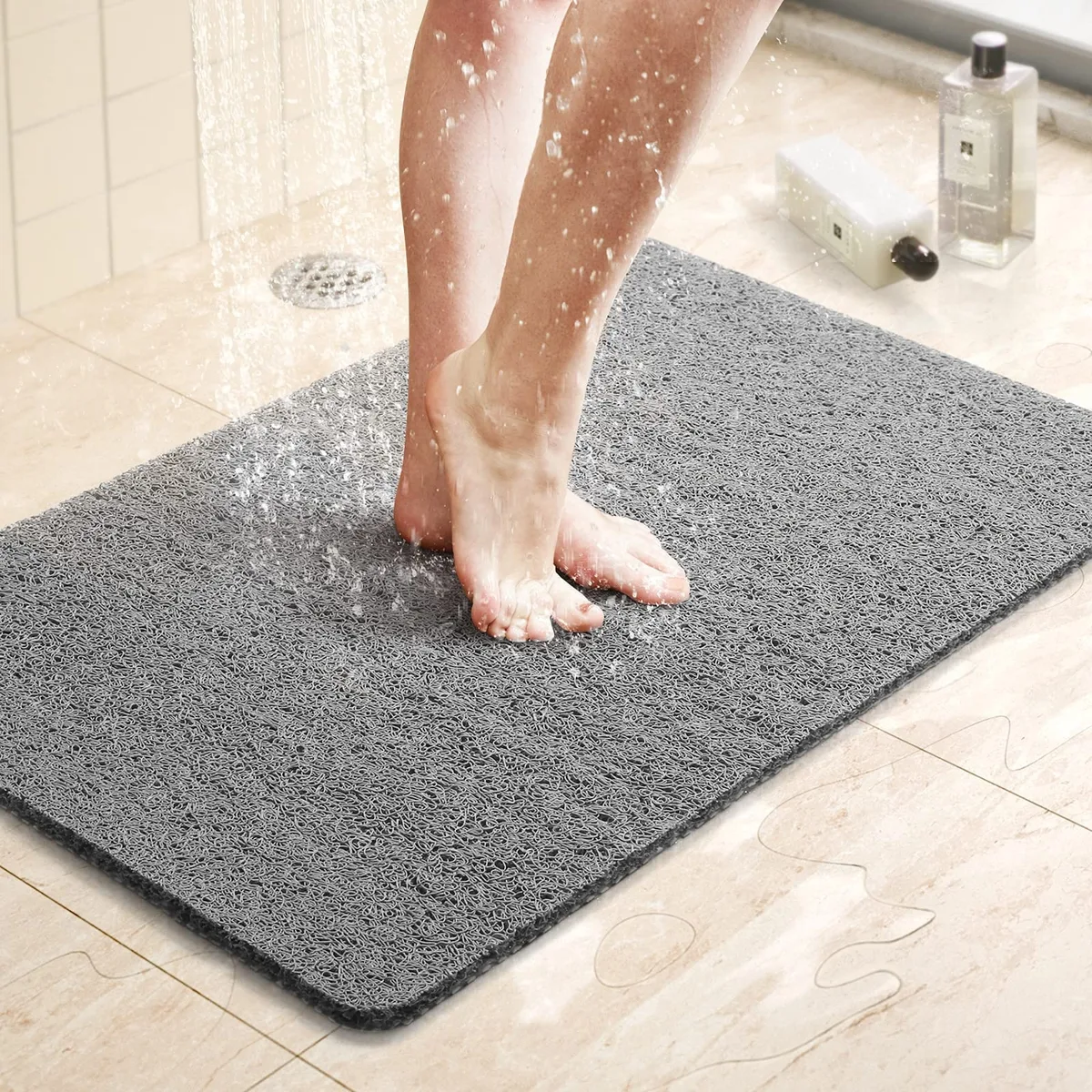 Grey rectangular PVC bath mat with woven texture and drain holes