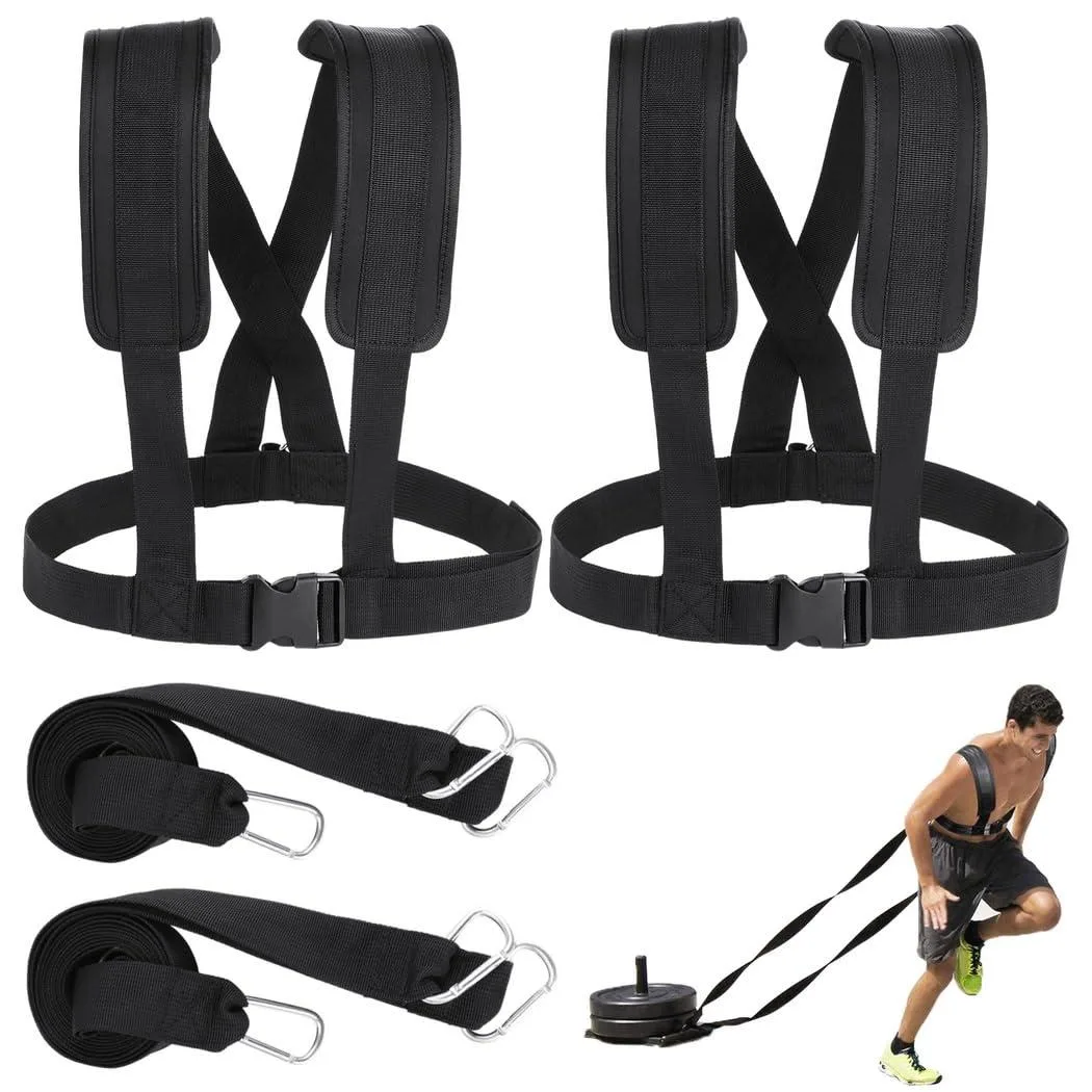 Two black nylon sled harnesses with padded shoulder straps and metal spring fasteners