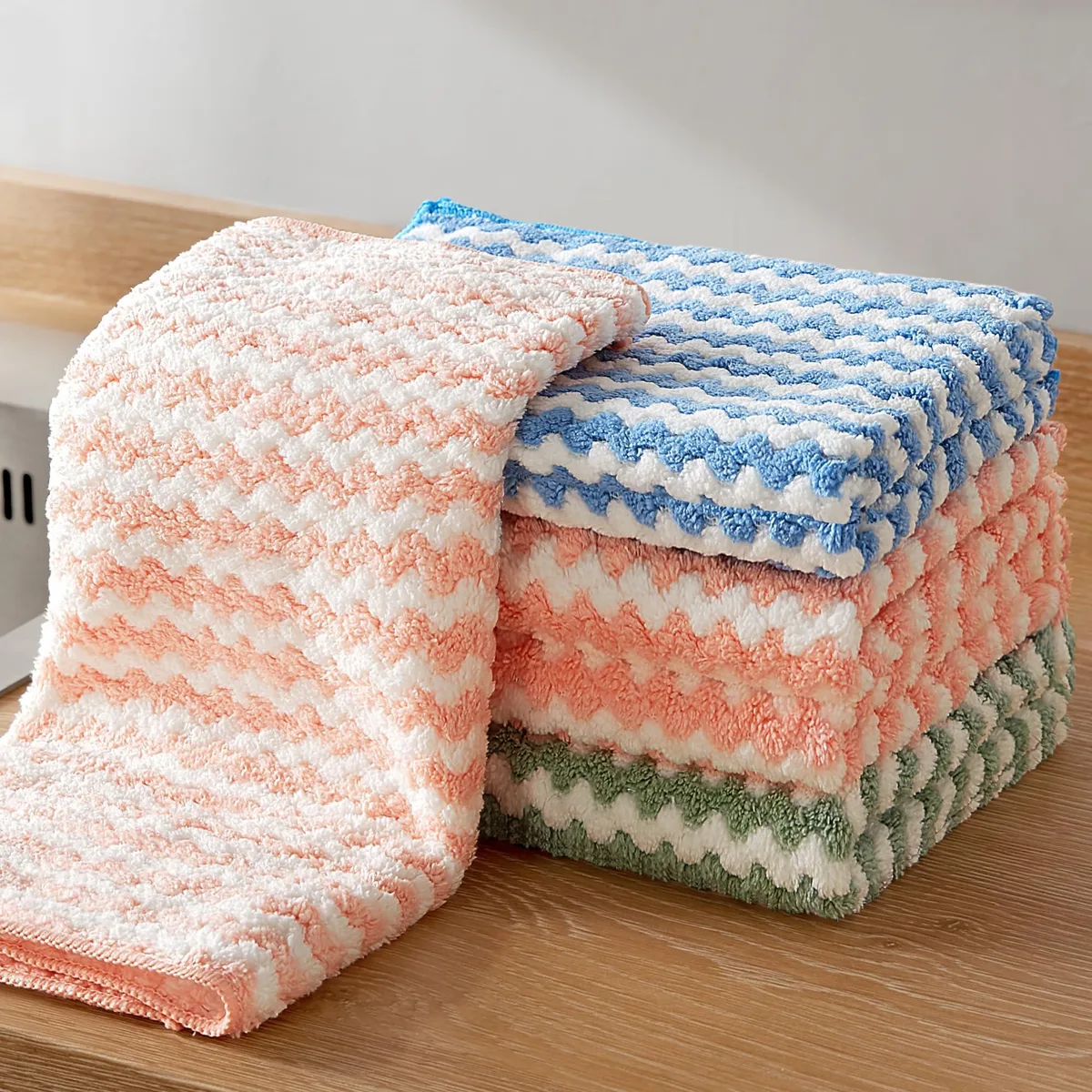 Five square blue microfiber cloths folded in a stack