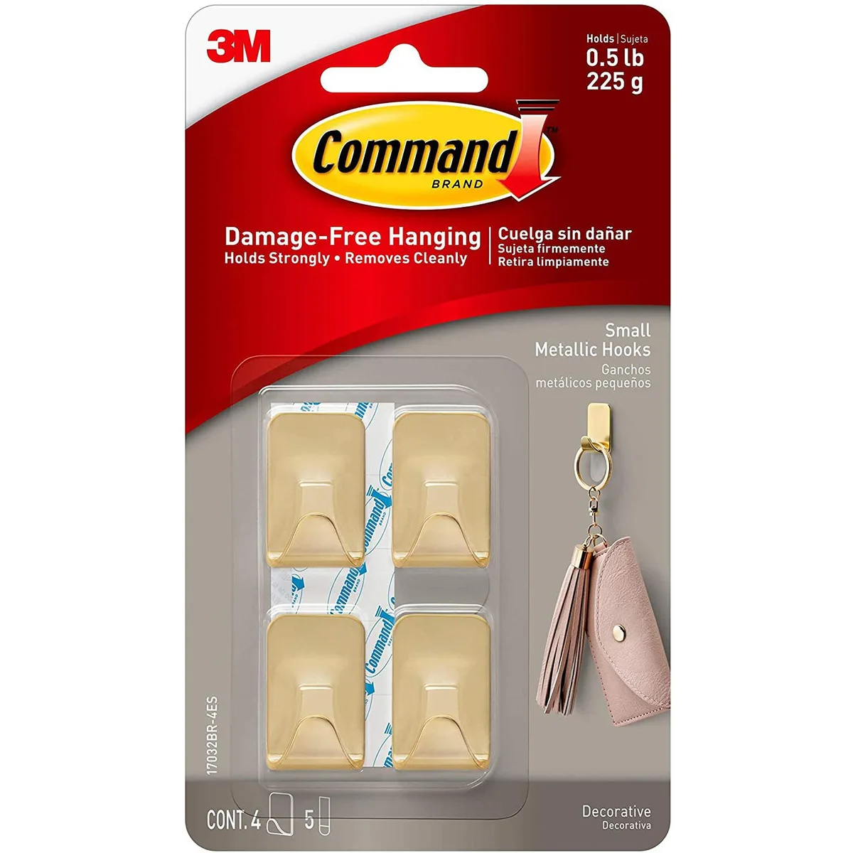 Four small brass metallic adhesive hooks in packaging
