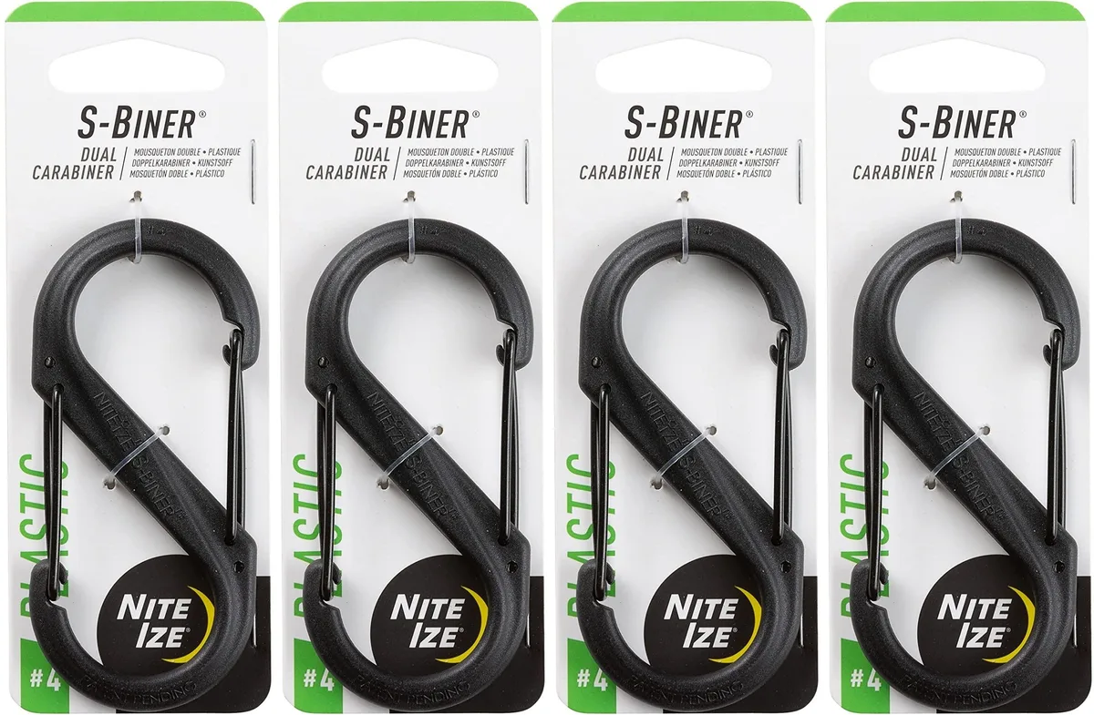 Four black plastic S-shaped carabiners with dual wire gates on a plain background