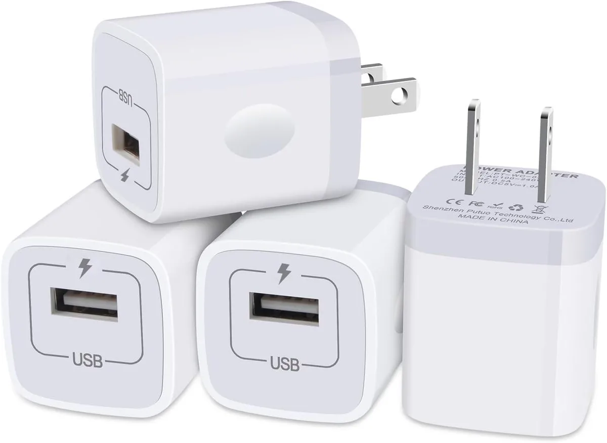 Four small white USB wall charger cubes