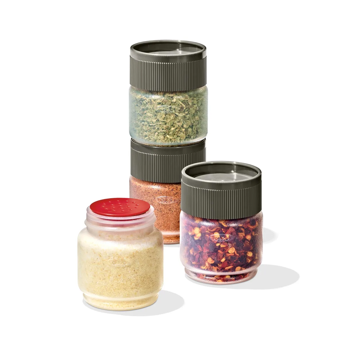 Four round plastic spice shakers snap together in a stack