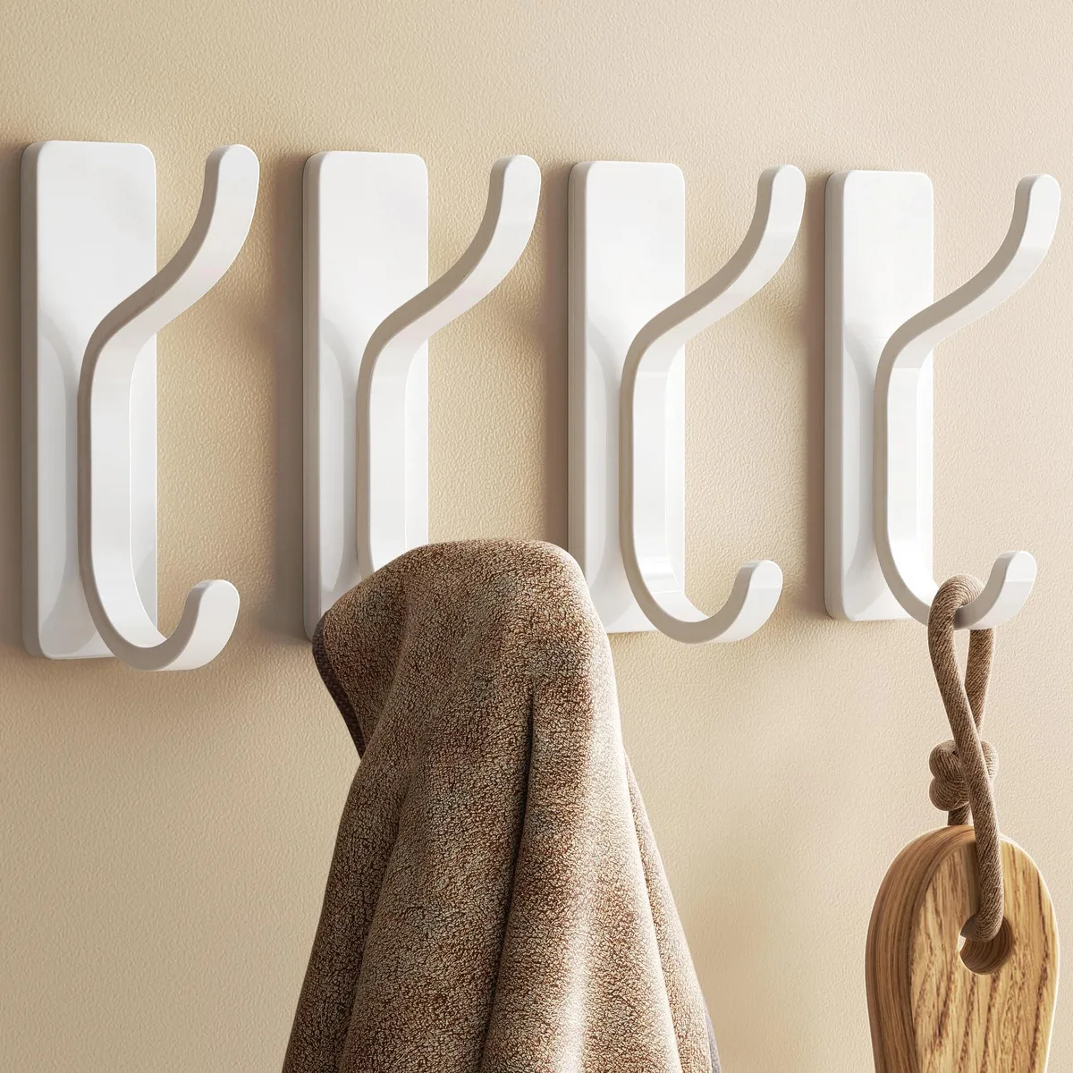Four white double adhesive wall hooks in a pack