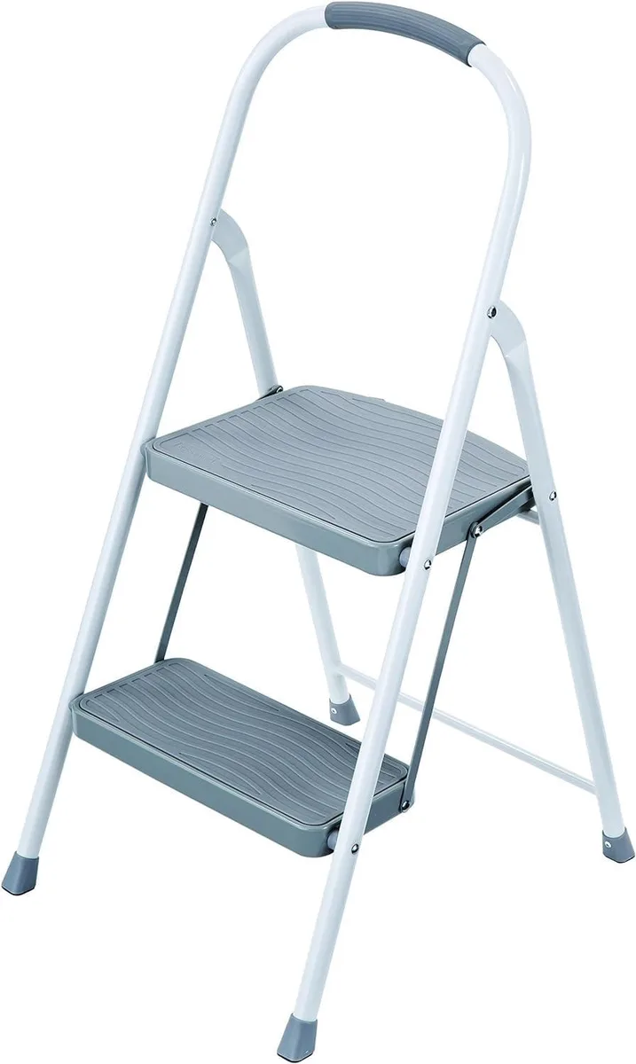 White two-step steel step stool with hand grip and rubber feet, folds flat