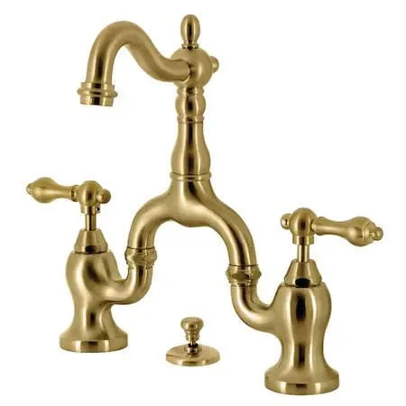 Brushed brass bridge bathroom faucet with cross handles and matching pop-up drain
