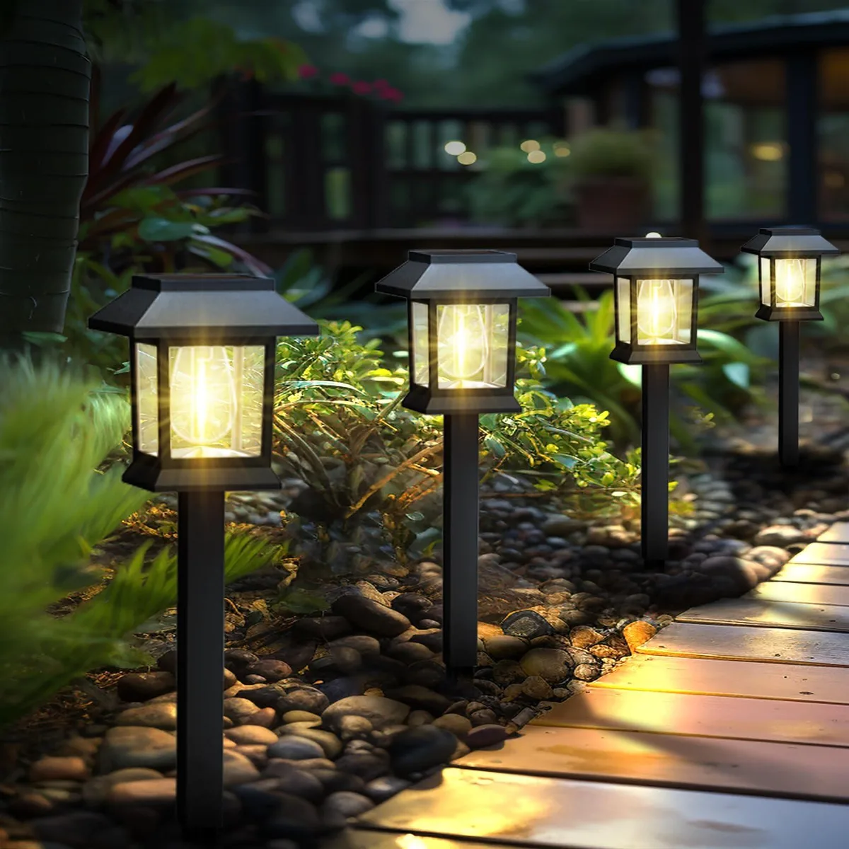 Twelve black resin pathway lights with clear plastic shades and warm LED bulbs standing on metal stakes
