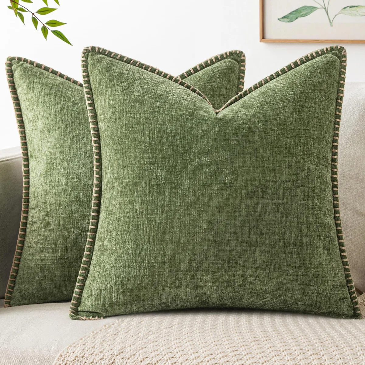 Two square sage-green chenille pillow covers with brown stitched edges and invisible zippers