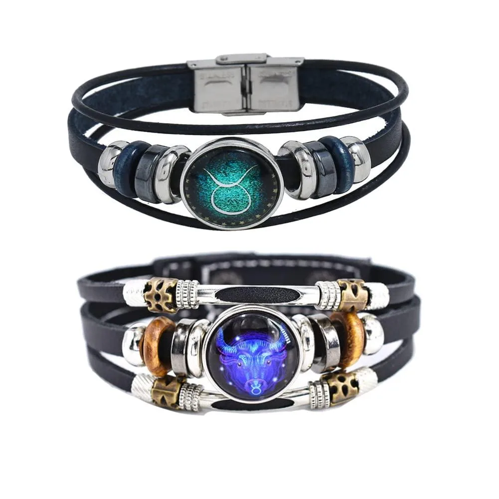 Two braided leather wrap bracelets with alloy Taurus charms, adjustable snap closures, unisex sizing
