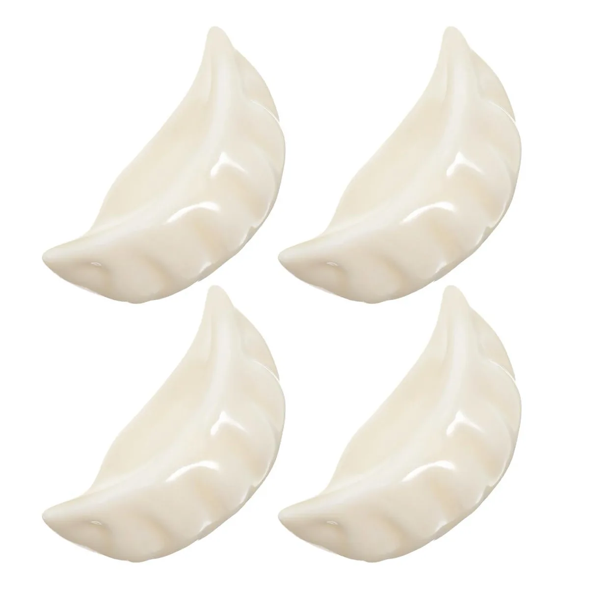 Four small silver dumpling-shaped ceramic chopstick rests on a table